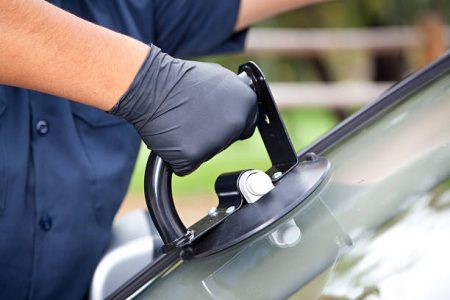Man repairing and replacing the glass on a car.